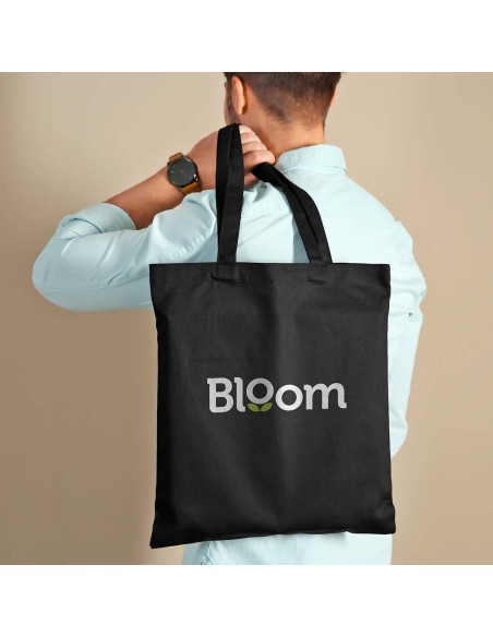 boy with a black tote bag with long handles hanging from his shoulder, customizable with your logo