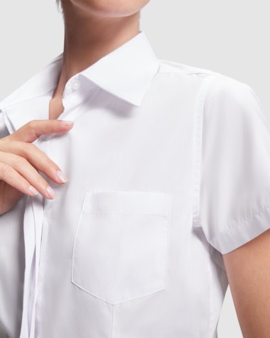 Front detail of the pocket of the embroidered women's work shirt as a work uniform Front detail of the pocket of the embroidered women's work shirt as a work uniform