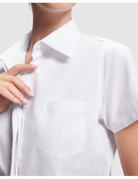 Front detail of the pocket of the embroidered women's work shirt as a work uniform Front detail of the pocket of the embroidered women's work shirt as a work uniform