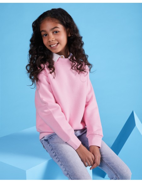 Girl with classic pink Roly unisex junior sweatshirt